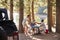 Three male friends make a toast at a picnic table by a lake