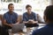 Three male friends talking over coffee at a coffee shop