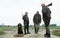 Three male hunters and dog with hares. low perspective. Rural area. Winter season. Proud hunting dog sitting with the catch.