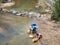 Three Man Filling Water Into Jerry Can in the River