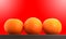 Three mandarin oranges shot over red background