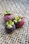 Three mangosteens on a woven bamboo basket