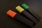 Three markers on a black background.
