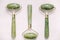 Three massage rollers made of green jade stone on a white background. Top view. Copy, empty space for text