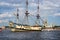 Three masted yellow wooden Tall Ship on the River Neva with Peter and Paul Cathedral in background in St Petersburg, Russia