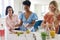 Three Mature Female Friends At Home Having Fun Mixing Cocktails Together