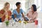 Three Mature Female Friends At Home Having Fun Mixing Cocktails Together