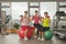 Three mature women exercising with fitness ball and holding weights in the gym