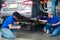 Three mechanic checking wheel and car body at garage, car service technician check and repair customer car at automobile service,