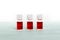Three medicine vials filled with red liquid close up