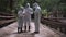 Three men in biohazard suits standing on a bridge