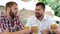 Three men in cafe drinking light beer, talking