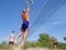 Three men play beach volley