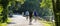 Three men riding bicycles on trail passing a lake in the woods