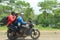 Three men riding motorcycle without helmet