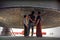 Three men standing under a giant bell, looking up and admiring the impressive object at Mingun, Myanmar.