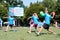 Three Men Throw In Unison At Outdoor Dodge Ball Game