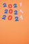 Three mentions of 2021 on orange background. New year concept