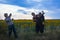 three middle-aged women friends are joking and laughing in a field of sunflowers