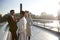 Three millennial colleagues stand talking on Millennium Bridge as the sun goes down