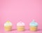 Three mini cupcakes on pink copy space