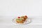 Three mini sandwiches on a plate on white wooden background, copy space
