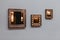 Three mirror frames on grey wall. Triptych scenery frames mirrored golden copper color