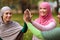 Three Modern Muslim Ladies Giving High-Five Standing In Park Outside