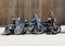 Three motorcycles parked by wooden fence