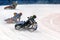 Three motorcyclists in a steep ice bend