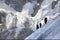 Three mountaineers walking across Mont Blanc high mountain range