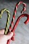 Three multi-colored lollipops canes clutched in the hand of the woman. three candy canes holds in hand