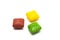 Three multicolored square candies with a shadow