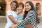 Three multicultural women embracing themselves