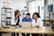 three multiracial doctors, working together with laptop, while sitting at the table in modern clinic