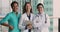 Three multiracial female therapists wear uniforms smile look at camera