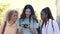 Three multiracial friends looking at the photos in a camera in Madrid, Spain.