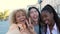 Three multiracial happy friends taking a selfie and laughing in Madrid, Spain.