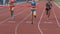 Three multiracial participants of running race crossing finishing line, slow-mo