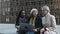 Three multiracial young business women working together on laptop outdoors