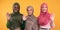 Three Muslim Ladies Waving Hello Gesture Over Yellow Background, Panorama