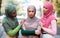 Three Muslim Women Comforting Supporting Unhappy Female Friend Standing Outdoors