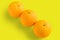 Three navel oranges on yellow background