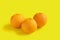 Three navel oranges on yellow background