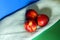 Three nectarines next to a towel on a green and blue background