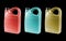 Three new plastic oil canister isolated on black background.  Storage Tank. Canister for gasoline, diesel and gas. Yellow, red and