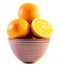 Three nicely colored oranges in a cup on a white background - front and back cut in half