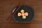 Three nigiri sushi served in black plate with chopsticks