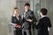 Three office workers chatting at door of boardroom