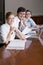 Three office workers working in boardroom